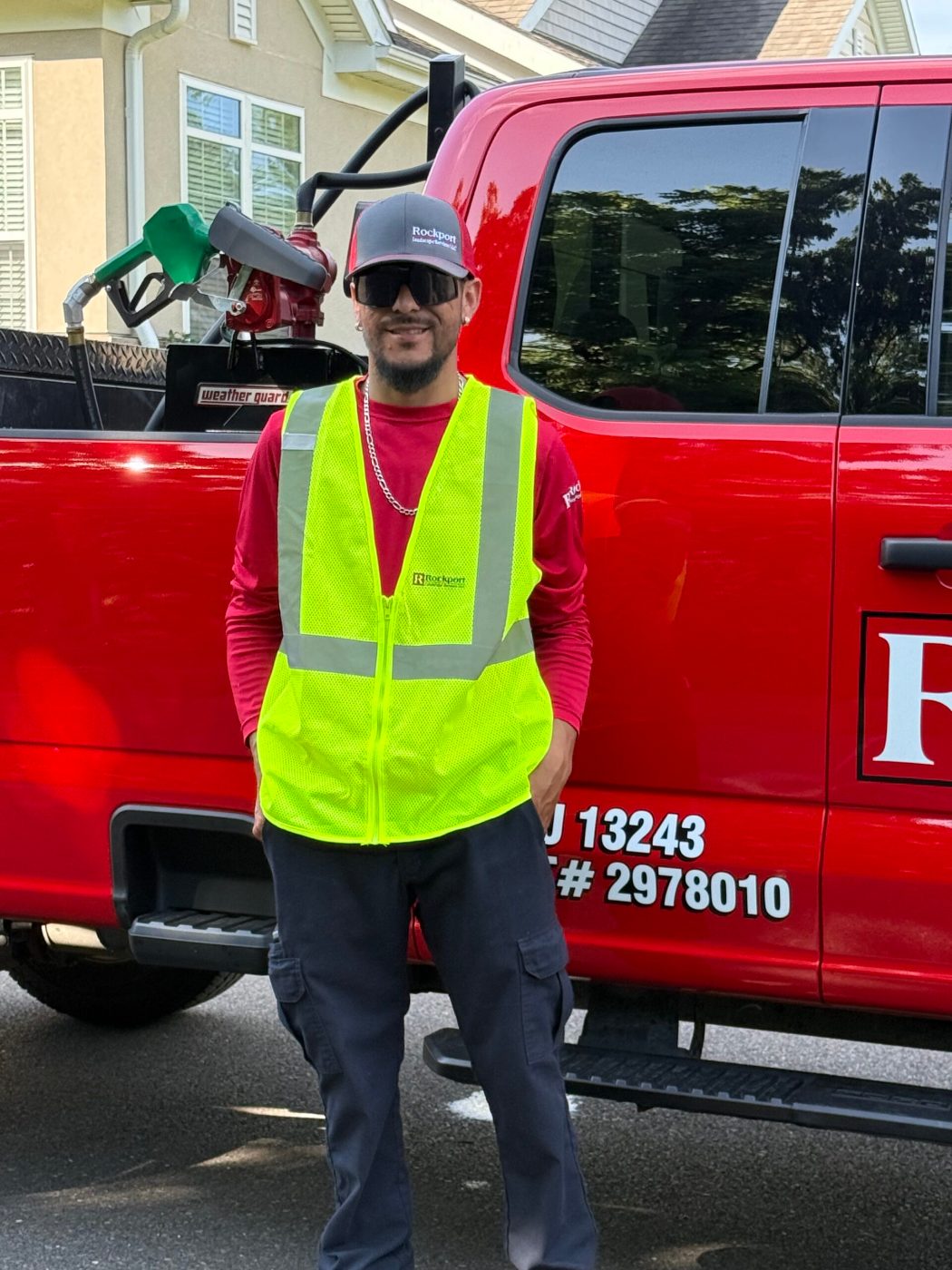 Rockport crew member in hi-vis vest and safety glasses beside a company truck